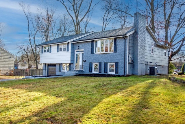 split foyer home with a front lawn, a garage, and central AC