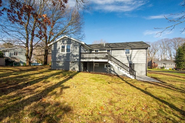 rear view of house featuring a lawn and a deck