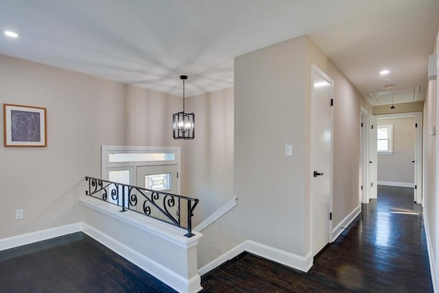 stairway with a notable chandelier and hardwood / wood-style flooring