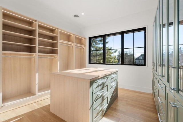 walk in closet with light wood-type flooring and visible vents