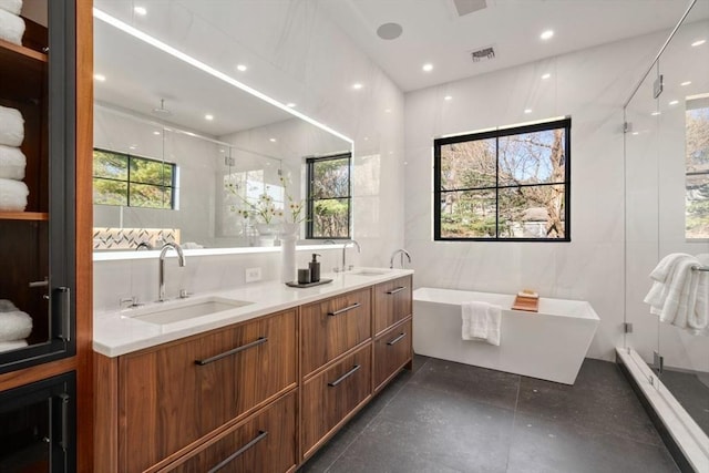 full bathroom with visible vents, a sink, a shower stall, and double vanity