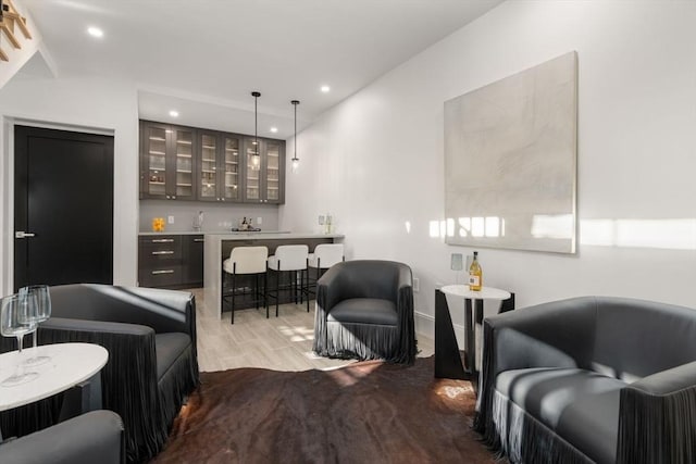 living room with recessed lighting, indoor wet bar, and wood finished floors