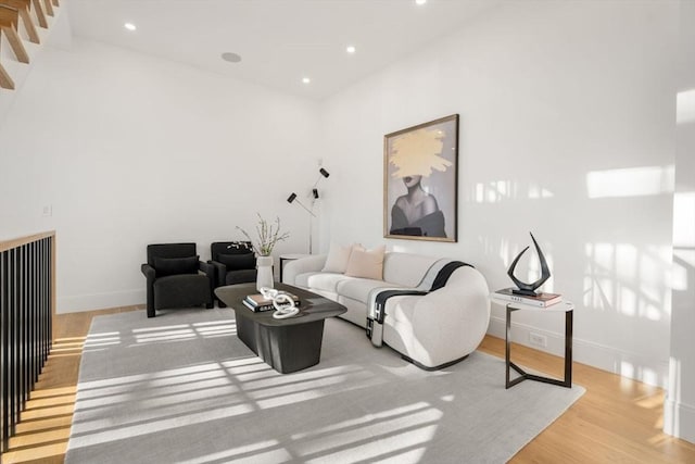 living area with baseboards, wood finished floors, and recessed lighting