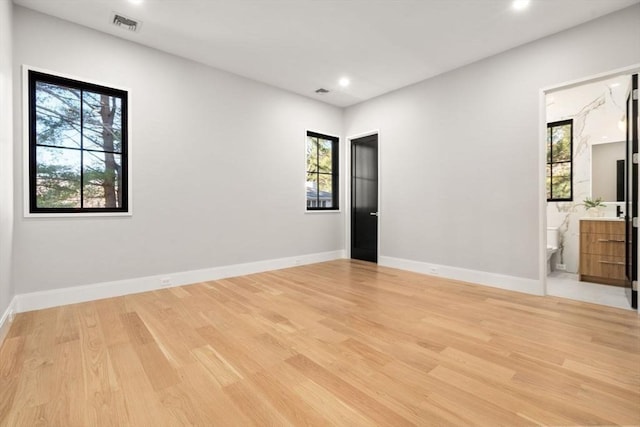 spare room featuring light wood-style floors, visible vents, baseboards, and recessed lighting