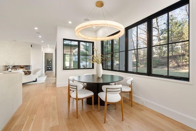 dining room with baseboards, light wood-type flooring, and recessed lighting