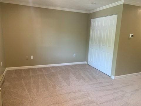 77 Adams St Unit 109, Quincy, MA 02169 - unfurnished bedroom featuring carpet, baseboards, ornamental molding, and a closet