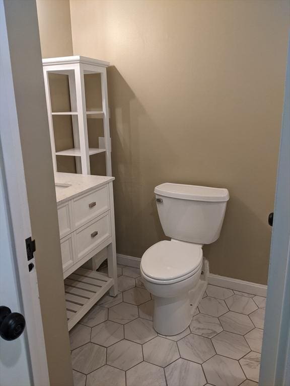 77 Adams St Unit 109, Quincy, MA 02169 - bathroom with baseboards, toilet, vanity, and tile patterned floors