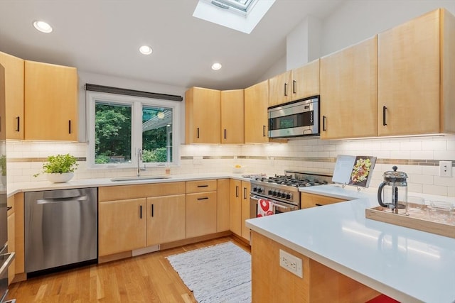 5 Mason St, Lexington, MA 02421 - kitchen featuring stainless steel appliances, light brown cabinets, a skylight, light countertops, and vaulted ceiling