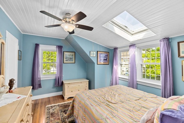 bedroom with dark wood-type flooring, ceiling fan, lofted ceiling with skylight, and multiple windows