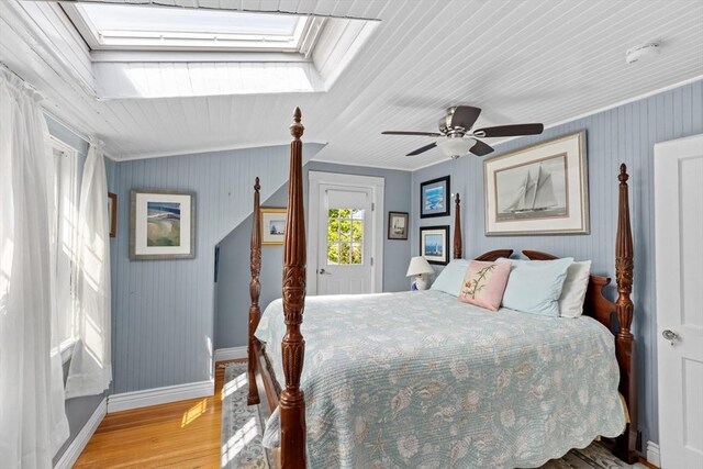 bedroom with ceiling fan, a skylight, ornamental molding, and hardwood / wood-style floors