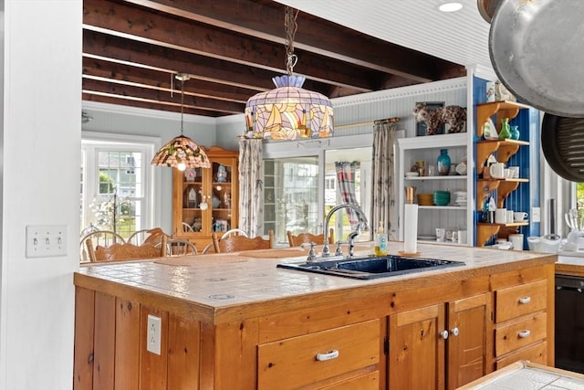 kitchen featuring decorative light fixtures, sink, beamed ceiling, and tile countertops