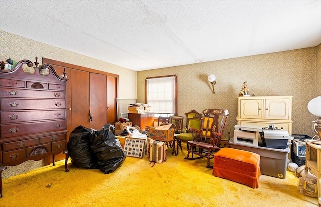 interior space with carpet flooring, a textured ceiling, and wallpapered walls