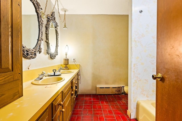 full bath featuring double vanity, baseboard heating, a sink, and a bath