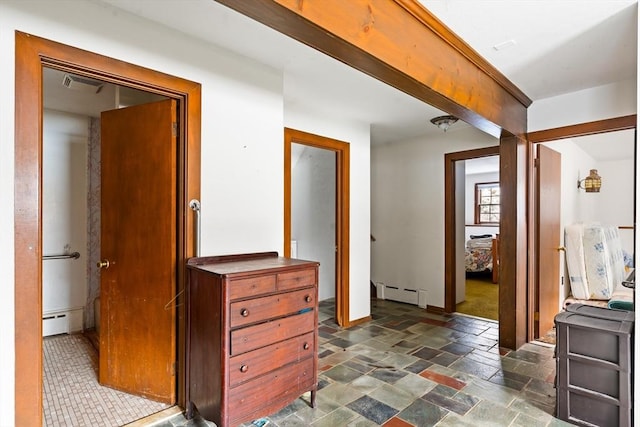 hallway featuring baseboards, stone tile floors, visible vents, and baseboard heating