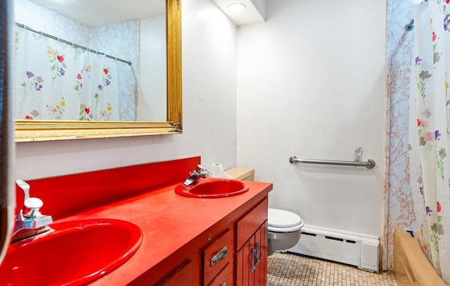 full bathroom with double vanity, toilet, a baseboard heating unit, a sink, and tile patterned floors