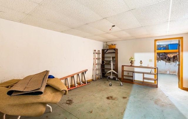 miscellaneous room featuring a paneled ceiling and unfinished concrete flooring