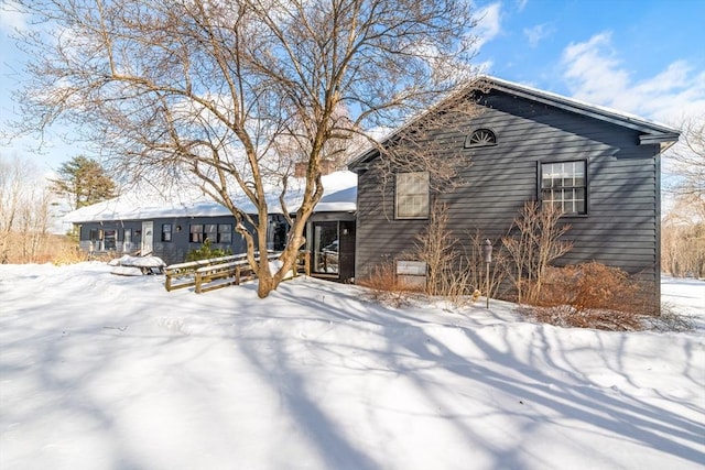 view of snow covered back of property