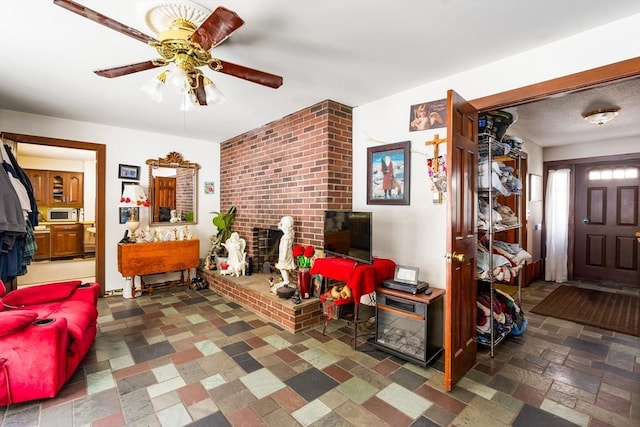 living area featuring a brick fireplace and stone tile floors