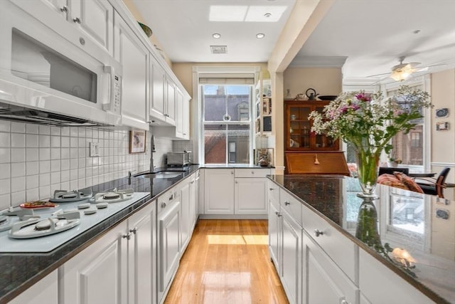 151 Beacon St Unit 4, Boston, MA 02116 - kitchen with white appliances, a sink, white cabinetry, light wood-style floors, and decorative backsplash