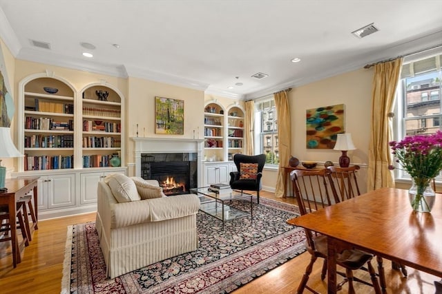 151 Beacon St Unit 4, Boston, MA 02116 - living room with a glass covered fireplace, ornamental molding, built in shelves, light wood-style floors, and recessed lighting