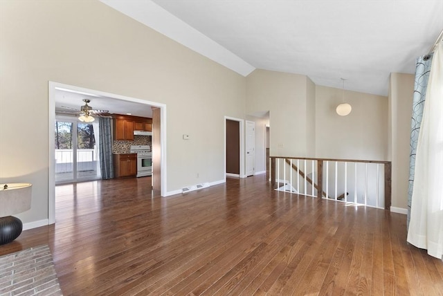 unfurnished living room featuring ceiling fan, dark wood-type flooring, and high vaulted ceiling