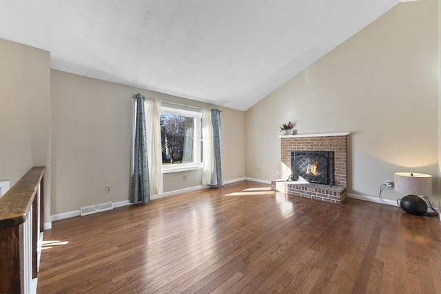 unfurnished living room featuring dark hardwood / wood-style flooring, a brick fireplace, and lofted ceiling