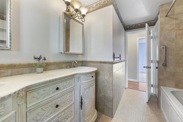 bathroom with tile patterned flooring, tiled shower / bath, vanity, and tile walls