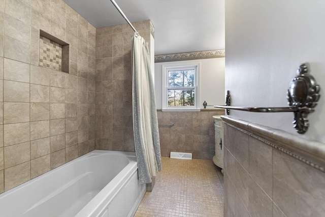 bathroom featuring tile patterned flooring, shower / bath combination with curtain, and tile walls