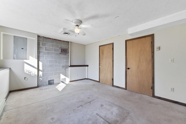 empty room featuring electric panel, ceiling fan, and light colored carpet