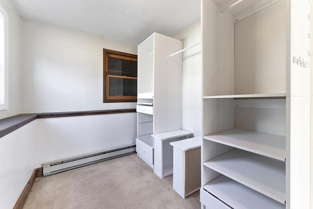 spacious closet featuring light carpet and a baseboard heating unit