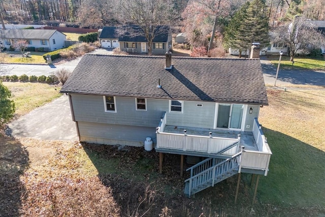 rear view of house with a deck and a lawn