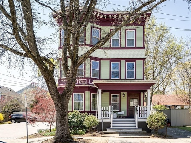 view of front facade featuring covered porch and fence