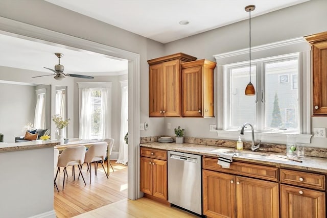 kitchen with ceiling fan, stainless steel dishwasher, brown cabinets, light wood-type flooring, and a sink