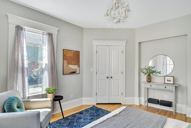 bedroom with light wood-style floors, a chandelier, and multiple windows