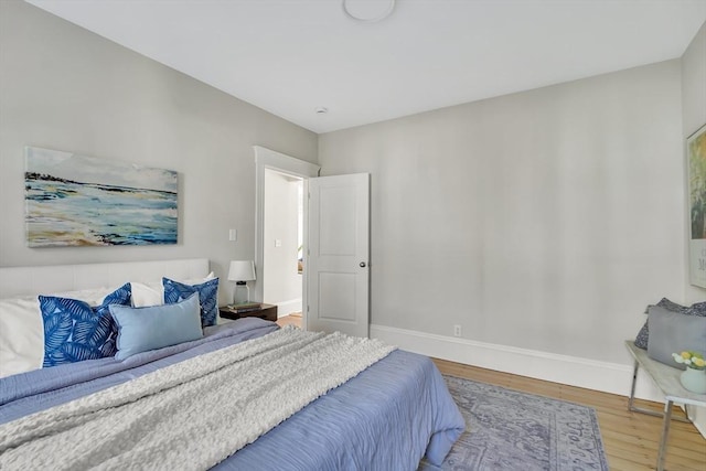 bedroom with baseboards and wood finished floors