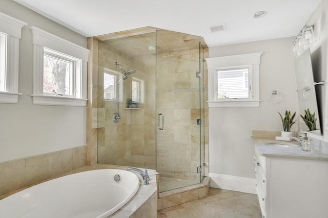 full bathroom featuring vanity, a stall shower, a bath, and a wealth of natural light