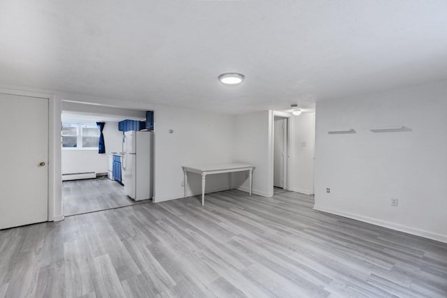 unfurnished room featuring light hardwood / wood-style floors and a baseboard radiator