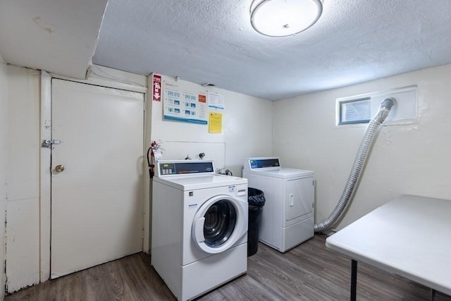 laundry room with a textured ceiling, independent washer and dryer, and wood-type flooring