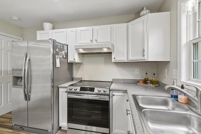 459 Brook St Unit C, Clinton, MA 01510 - kitchen with appliances with stainless steel finishes, under cabinet range hood, white cabinetry, and wood finished floors