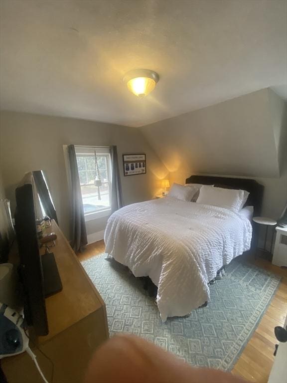 bedroom featuring light hardwood / wood-style flooring and vaulted ceiling