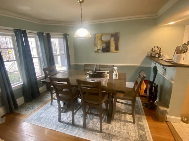 dining area featuring crown molding and light hardwood / wood-style flooring