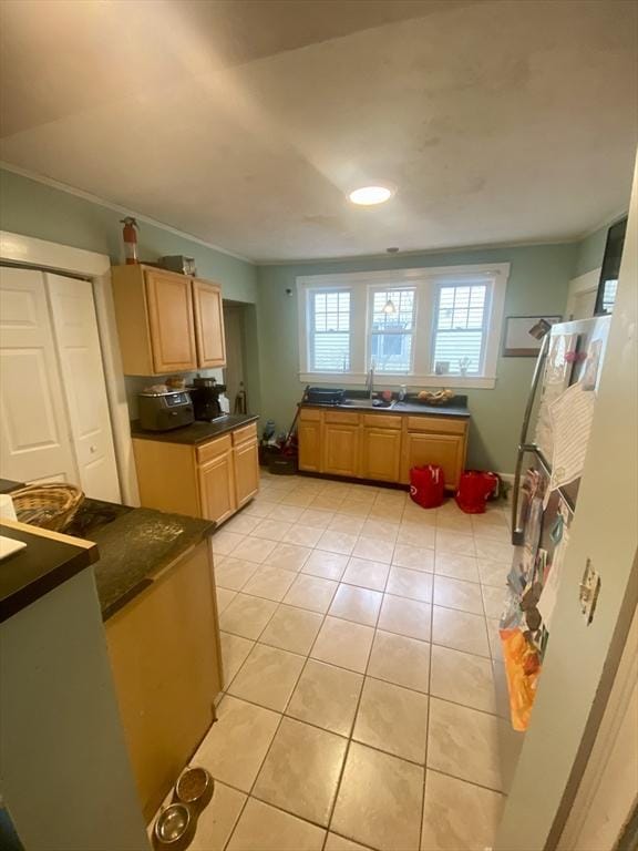 kitchen featuring light tile patterned floors, ornamental molding, and sink