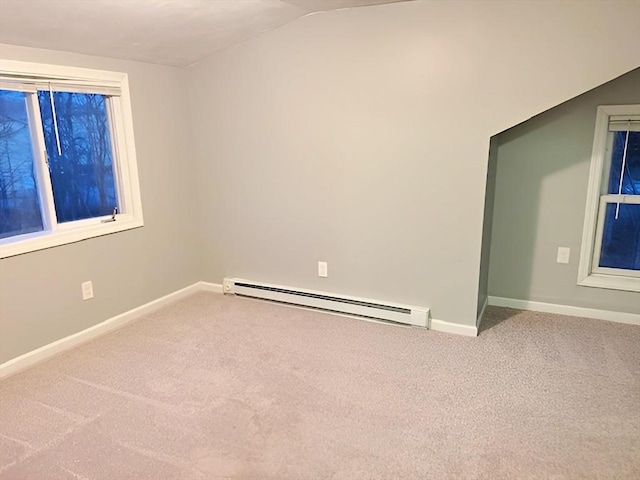 carpeted spare room with lofted ceiling and baseboard heating