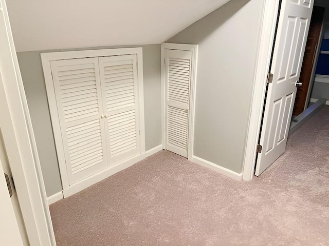 unfurnished bedroom featuring lofted ceiling and light carpet