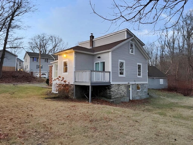 back of property featuring a yard and a deck