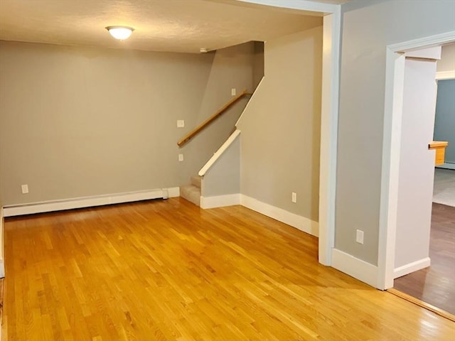 interior space featuring baseboard heating and hardwood / wood-style floors