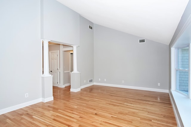 unfurnished room featuring ornate columns, light hardwood / wood-style flooring, and lofted ceiling