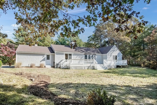 rear view of house featuring a yard and a deck