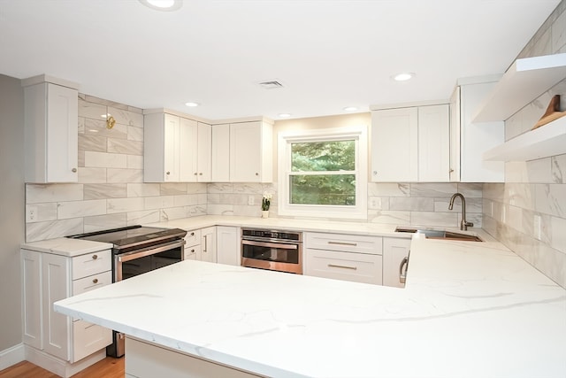 kitchen with white cabinetry, sink, stainless steel appliances, and light wood-type flooring