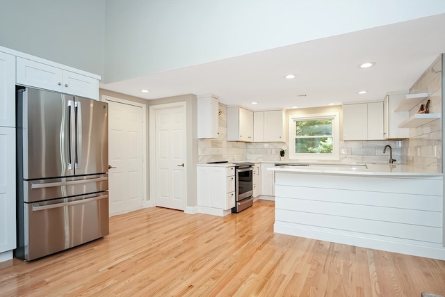 kitchen with white cabinets, stainless steel appliances, and light hardwood / wood-style floors